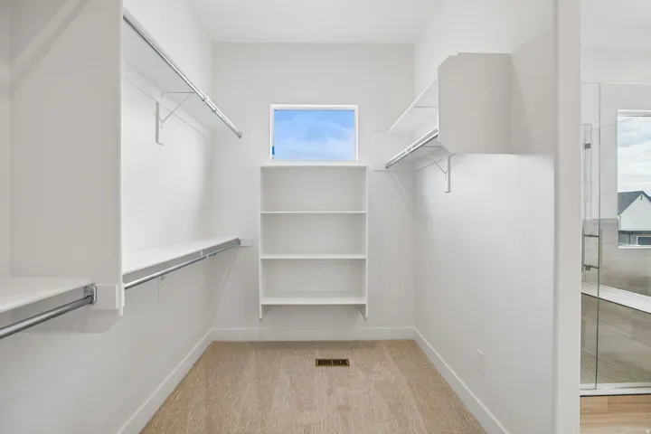 Wall-to-wall carpeting and built-in shelving with hanging rods