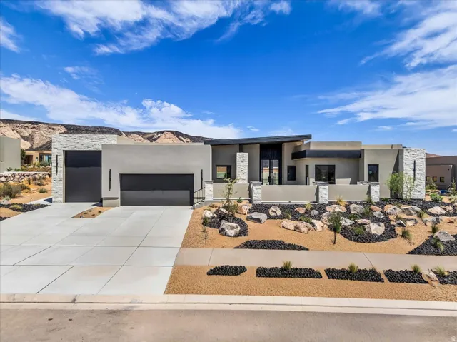 Contemporary desert-inspired architecture featuring a flat roofline and integrated two-car garage