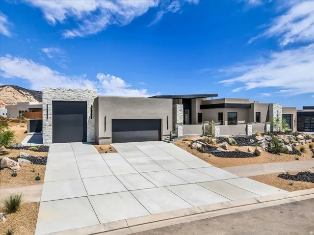 Modern desert architecture featuring a stucco exterior, stone accents, and a flat roofline