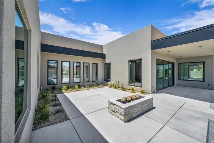 Expansive concrete patio area with a stone fire pit