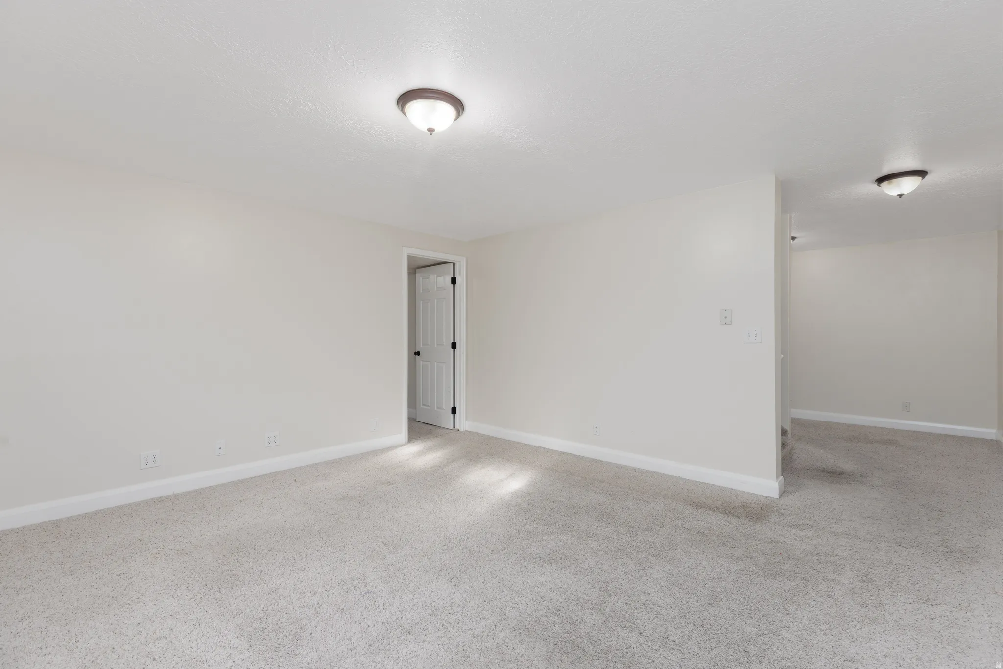 Neutral-toned carpeting throughout with white baseboards