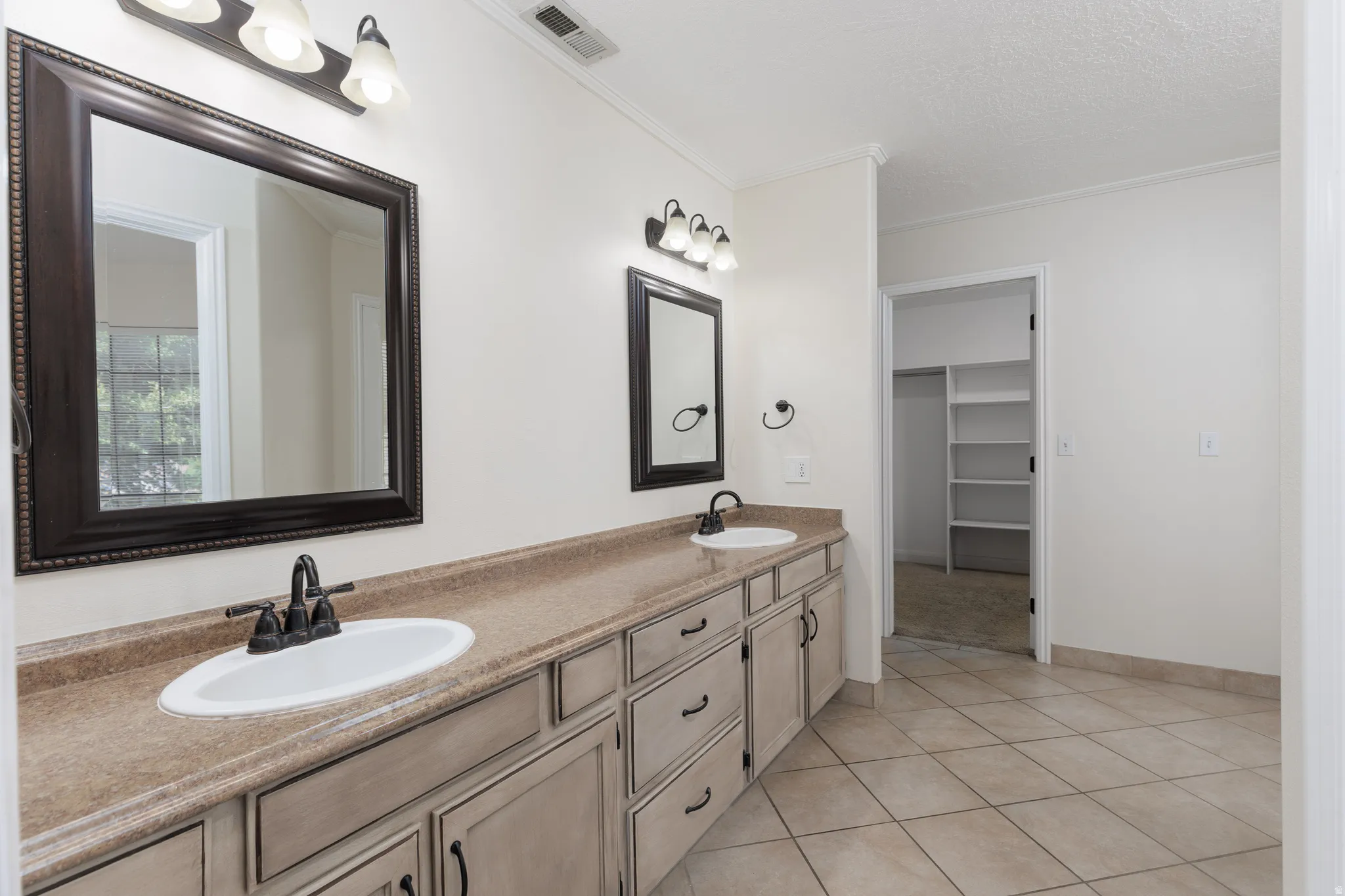 Dual vanities with integrated sinks, framed mirrors, and overhead lighting
