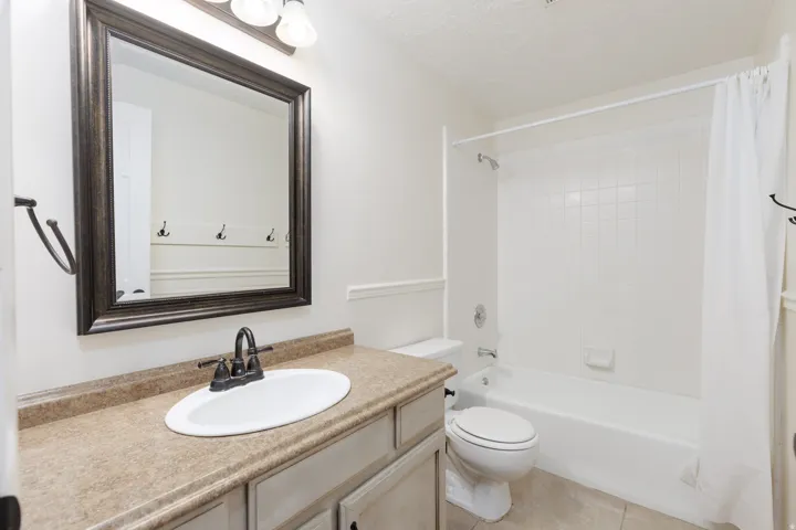 Bathroom featuring a single vanity with an oval sink, dark bronze-finish faucet, and a large framed mirror