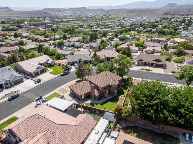 Aerial perspective of a neighborhood featuring residential properties with tile roofing and landscaped yards