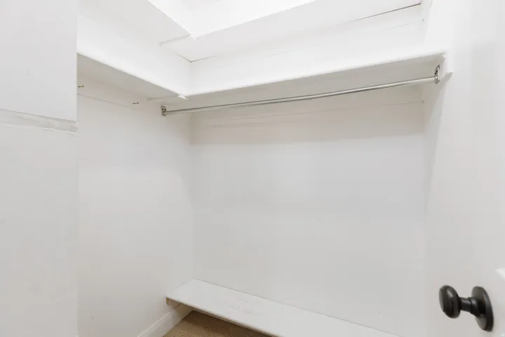 Recessed shelving, integrated clothing rod, and neutral wall finish