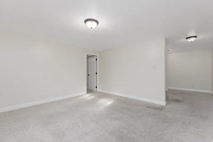 Neutral-toned carpeting throughout with white baseboards