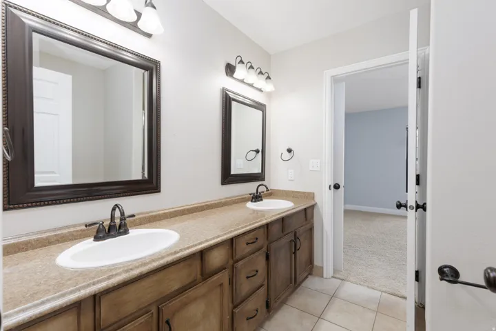 Dual vanity featuring integrated sinks, bronze-finish faucets, and framed mirrors