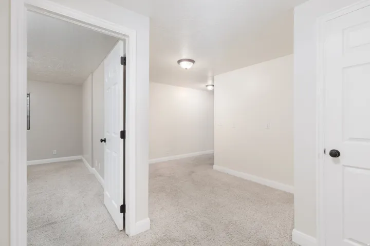 Plush carpeting throughout, white interior doors with dark hardware, recessed ceiling lights, and neutral wall tones