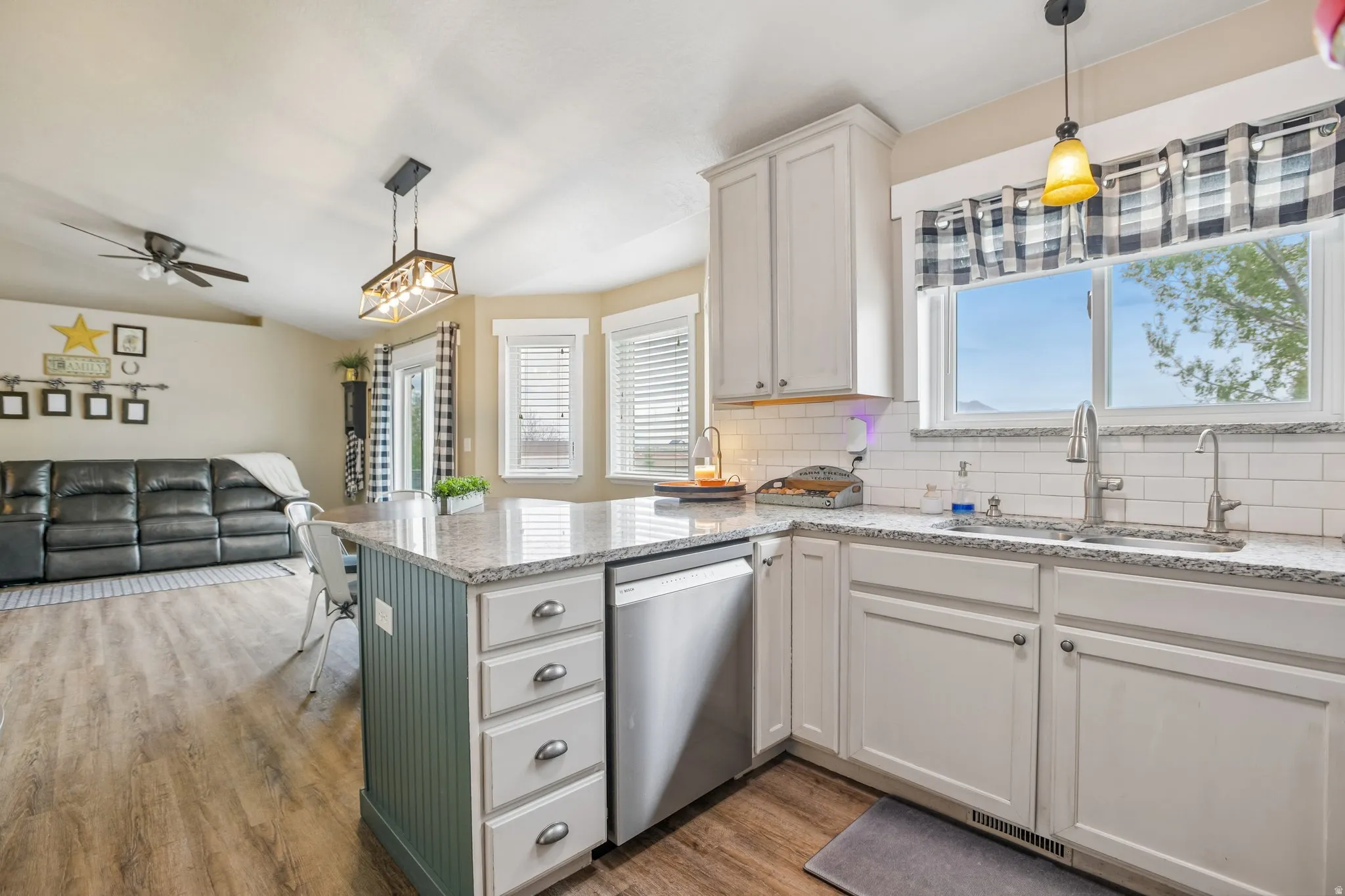 Kitchen featuring pendant lighting, light stone counters, light wood finished floors, and open floor plan