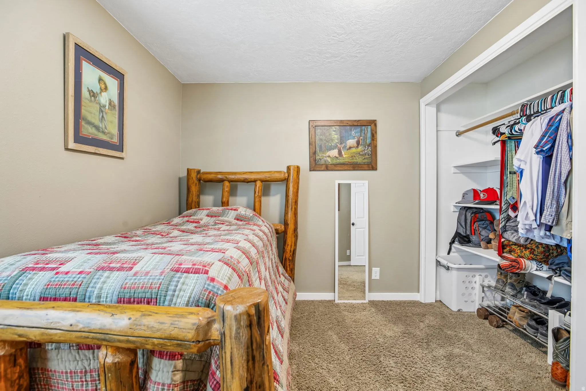 Bedroom with light carpet, a textured ceiling, and a closet