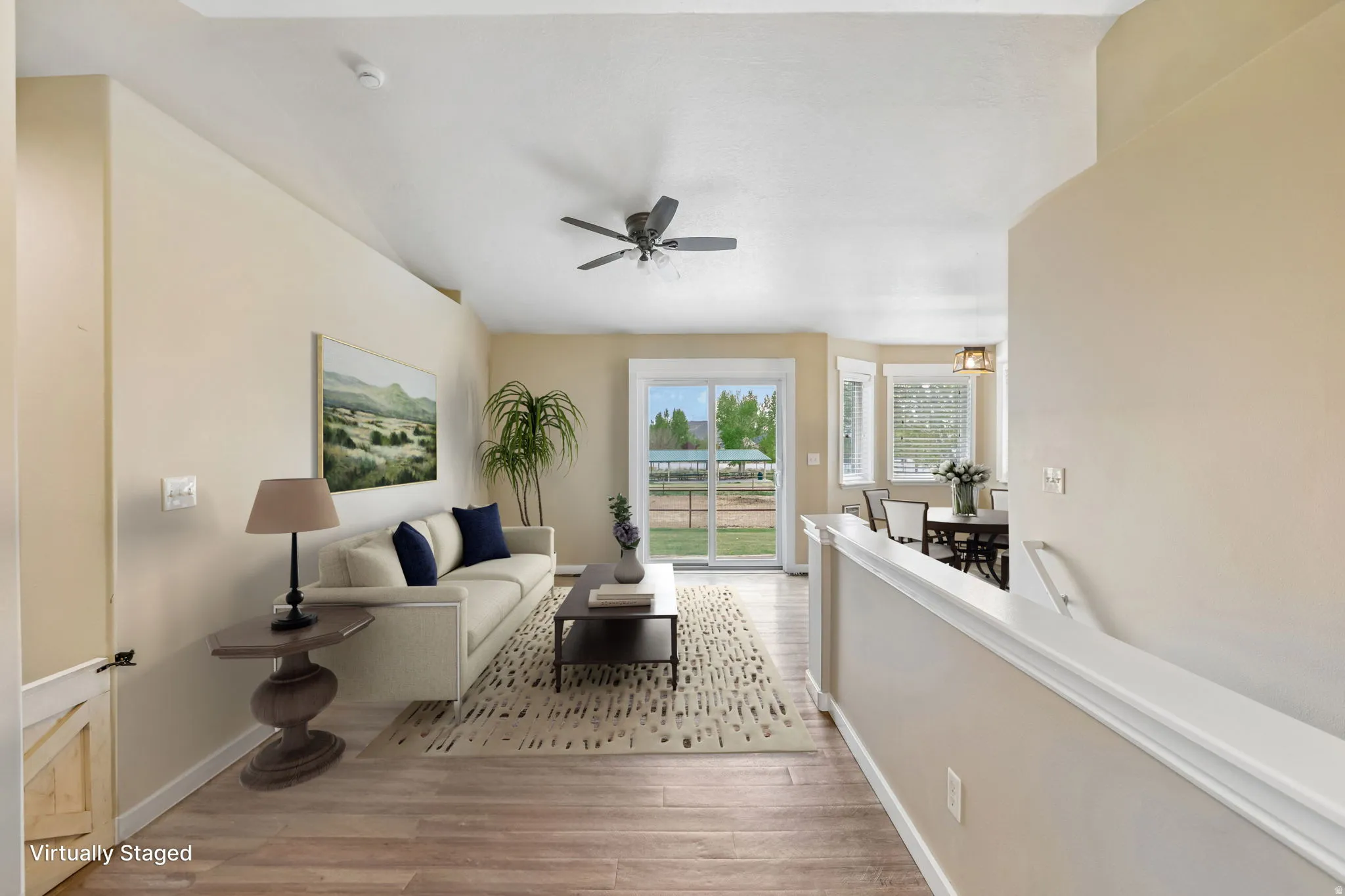 Vaulted ceiling with ceiling fan, wood-finish flooring, sliding glass door, multiple windows with blinds, and recessed lighting