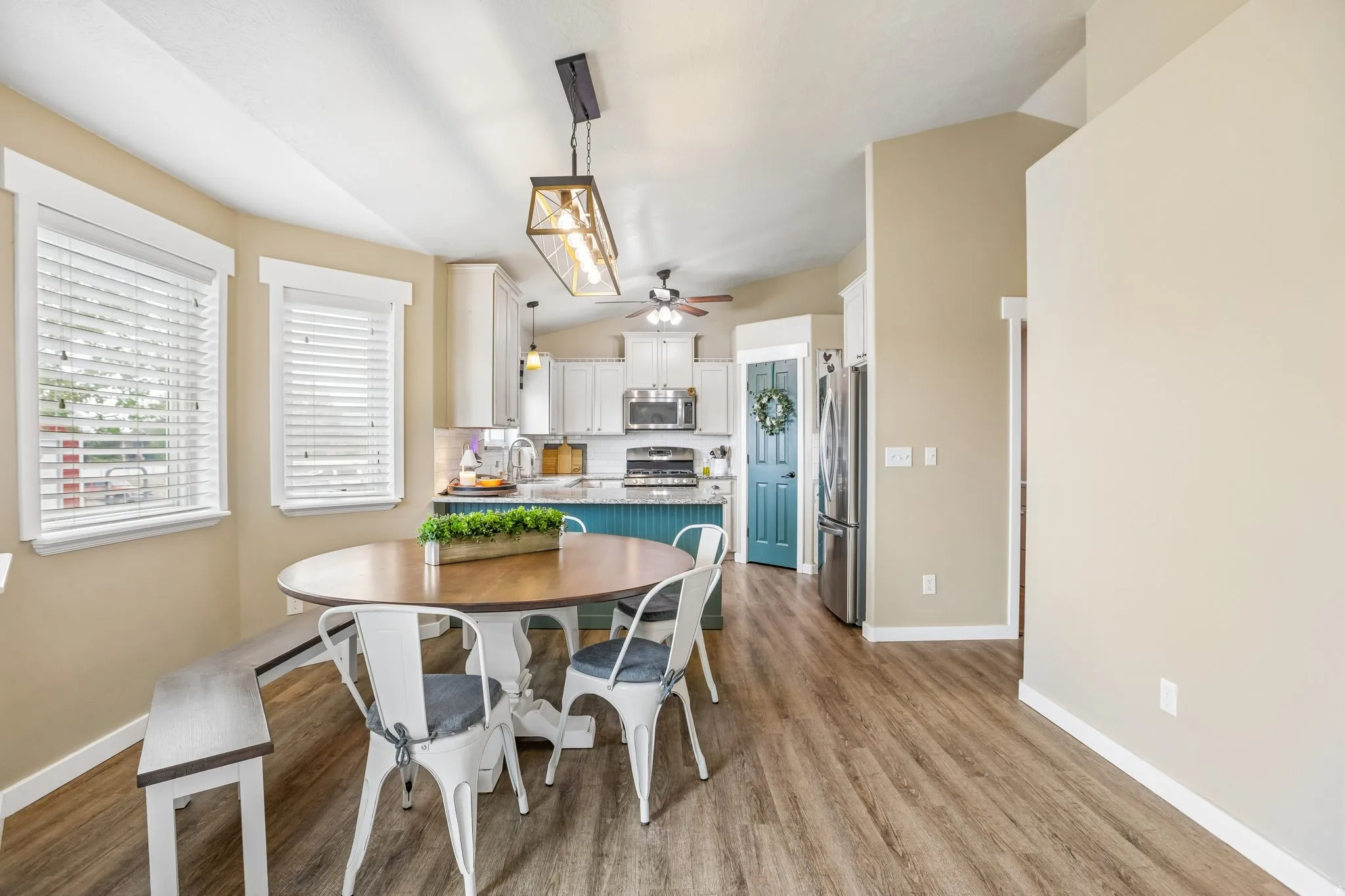 Dining area with light wood-style floors, a ceiling fan, and vaulted ceiling
