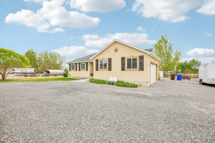 Ranch-style home with driveway, an attached garage, stucco