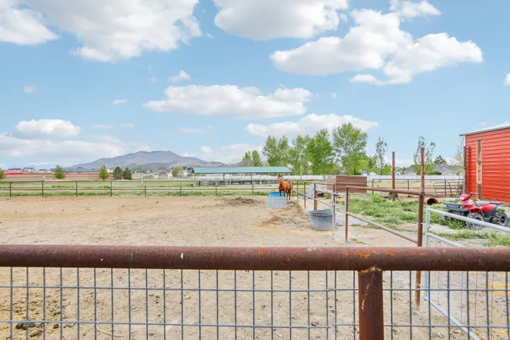 View of yard with a view of rural / pastoral area, an outbuilding, an exterior structure, and a mountain view