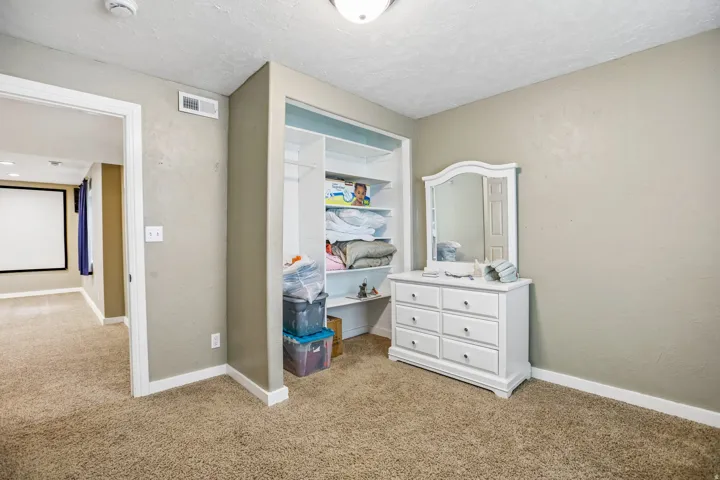 Bedroom featuring light colored carpet, a textured wall, and a textured ceiling