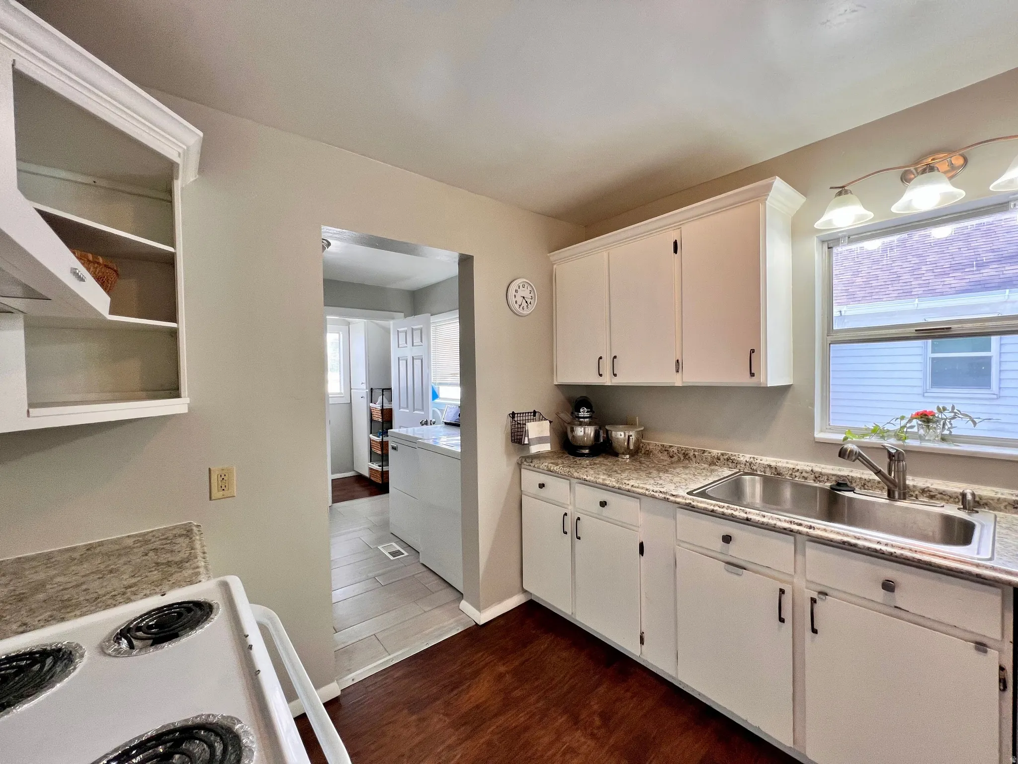 Kitchen featuring white electric stove, dark wood finished floors, white cabinets, and range hood
