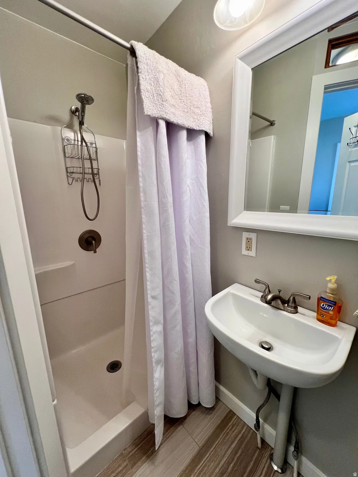 Full bathroom with a shower stall and baseboards