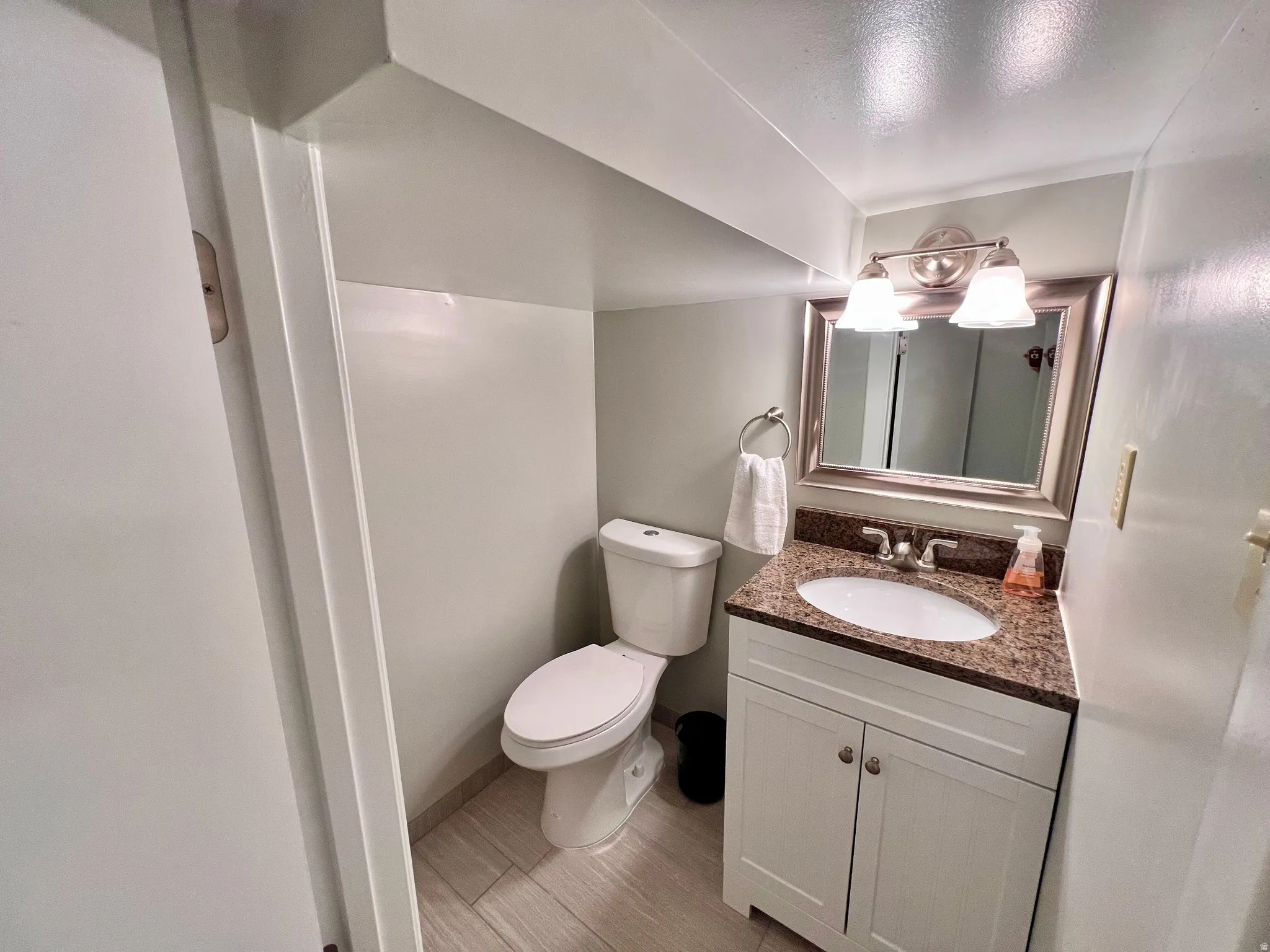 Half bathroom featuring vanity and toilet