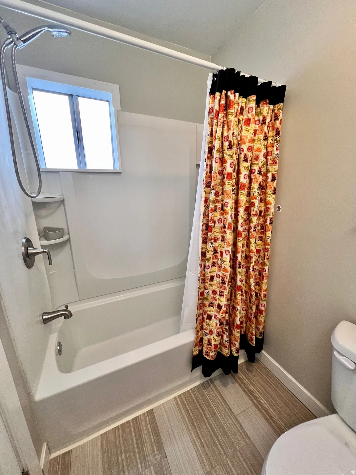 Full bath featuring shower / bathtub combination with curtain and toilet