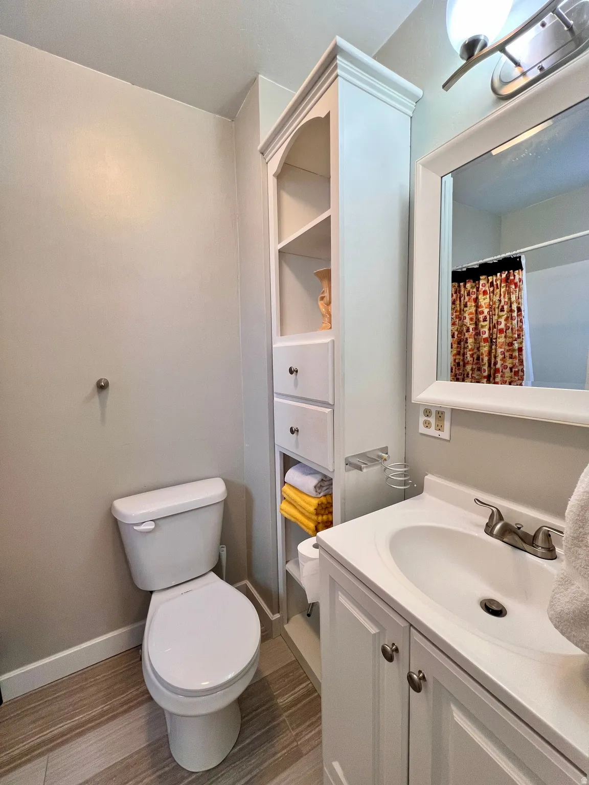 Bathroom featuring a shower with shower curtain and vanity