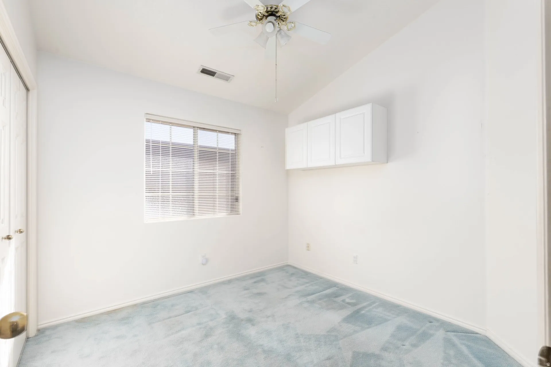 Unfurnished bedroom with lofted ceiling, a closet, a ceiling fan, and light carpet