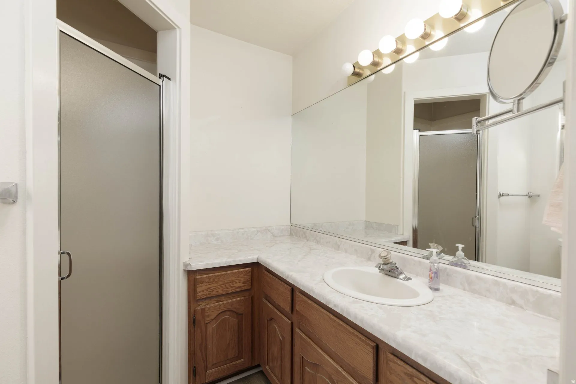 Full bathroom with vanity and a shower stall