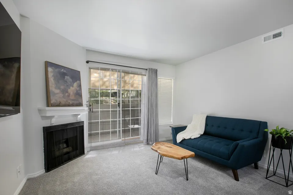 Living area with carpet and a fireplace