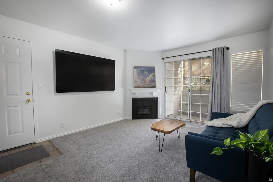 Living area featuring carpet flooring and a fireplace