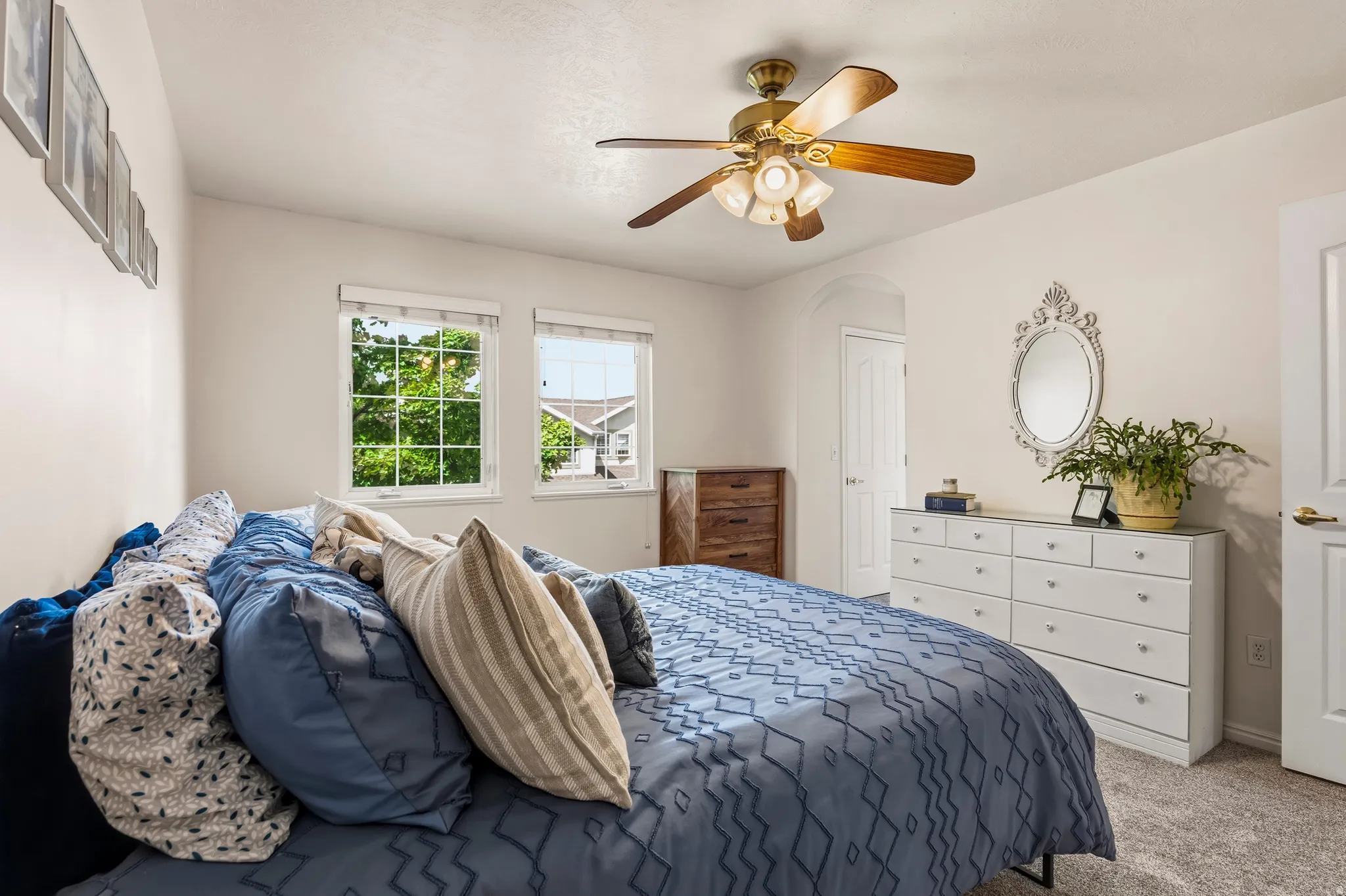 Bedroom with carpet flooring, ceiling fan, and arched walkways