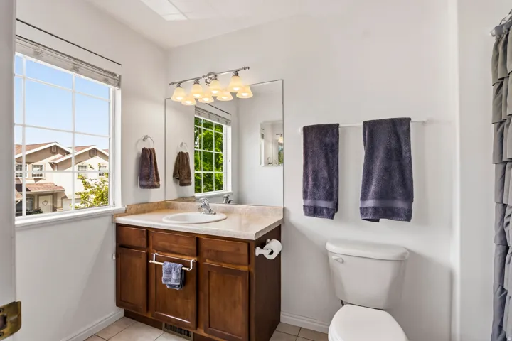 Bathroom featuring vanity, light tile patterned floors, and a shower with shower curtain