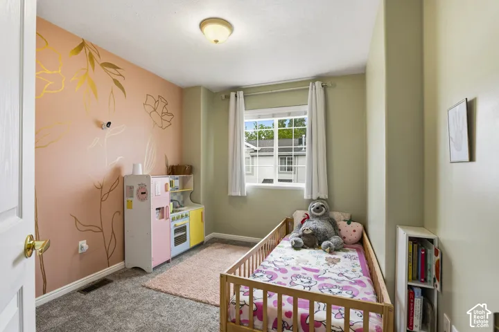 Bedroom featuring light carpet and baseboards