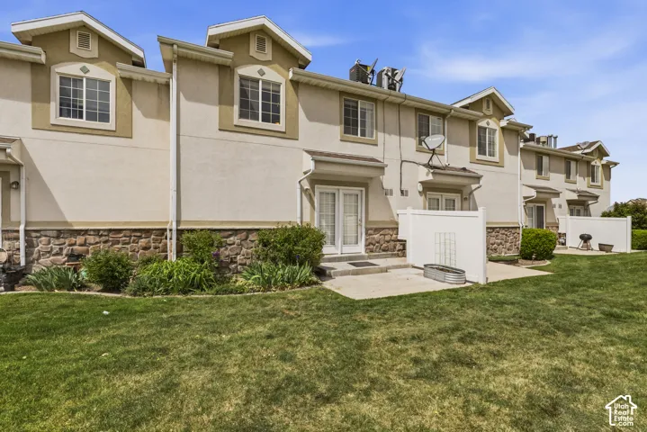View of front facade with stone siding, stucco siding, and a front yard