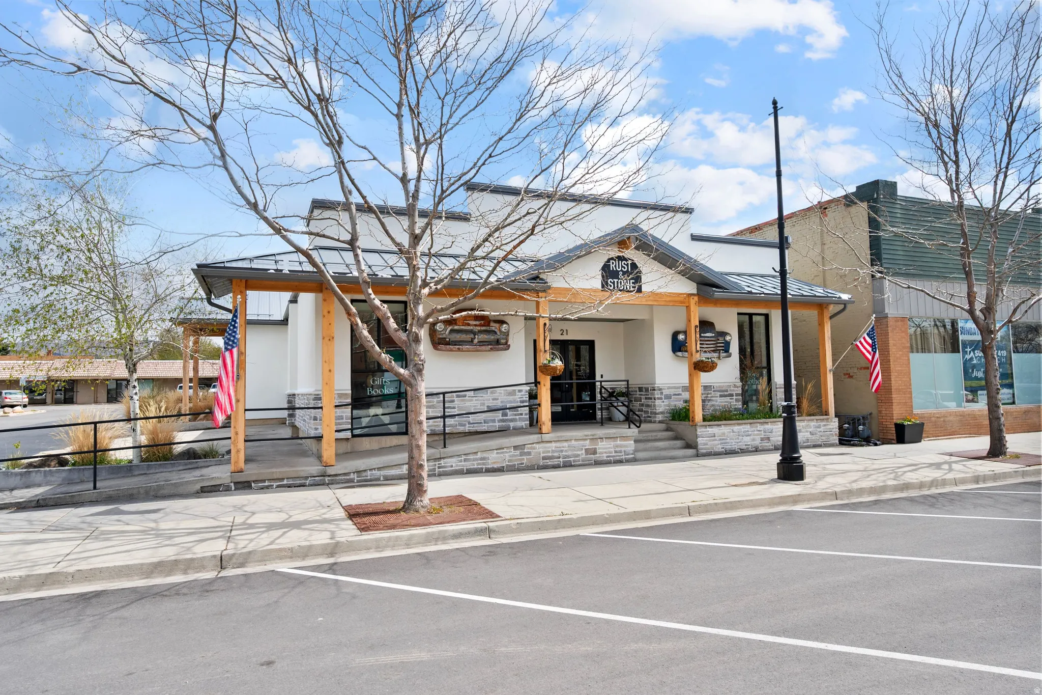 View of building exterior featuring uncovered parking and a fenced front yard