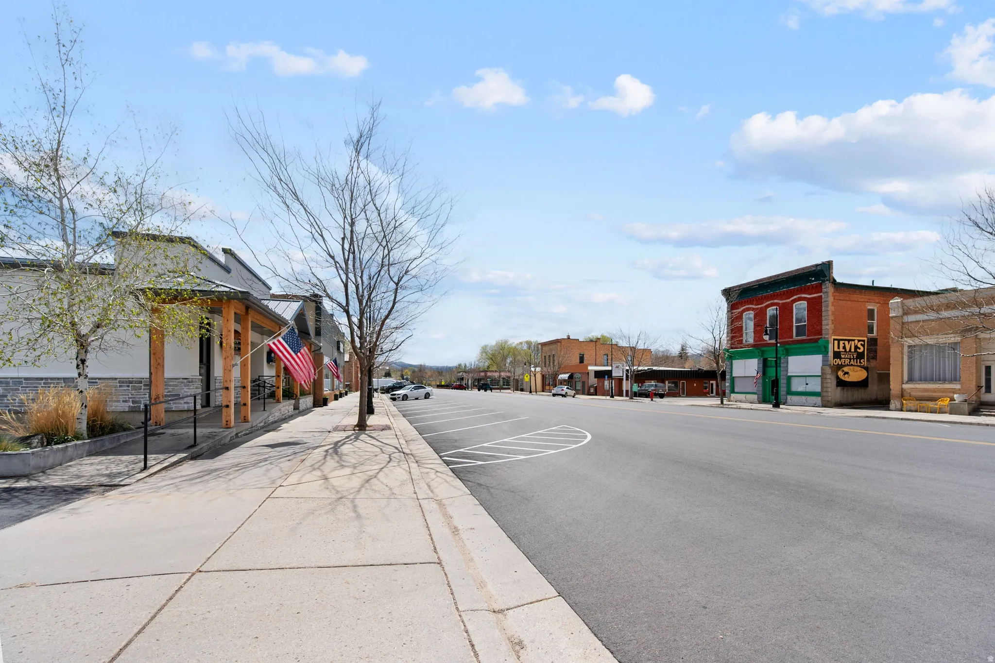 View of asphalt road featuring sidewalks and curbs