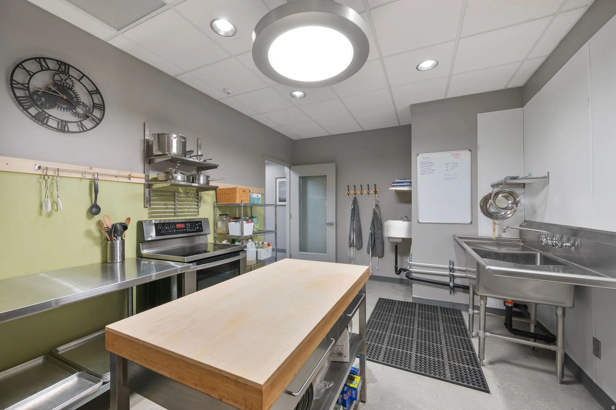 Kitchen featuring stainless steel counters, stainless steel electric range, a paneled ceiling, recessed lighting, and pet washing station