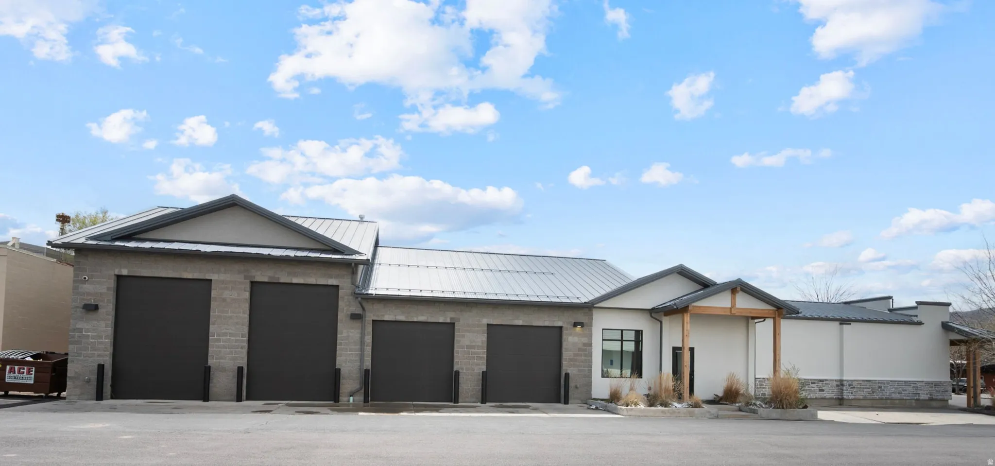 View of front of home with a garage, stucco siding, and a standing seam roof