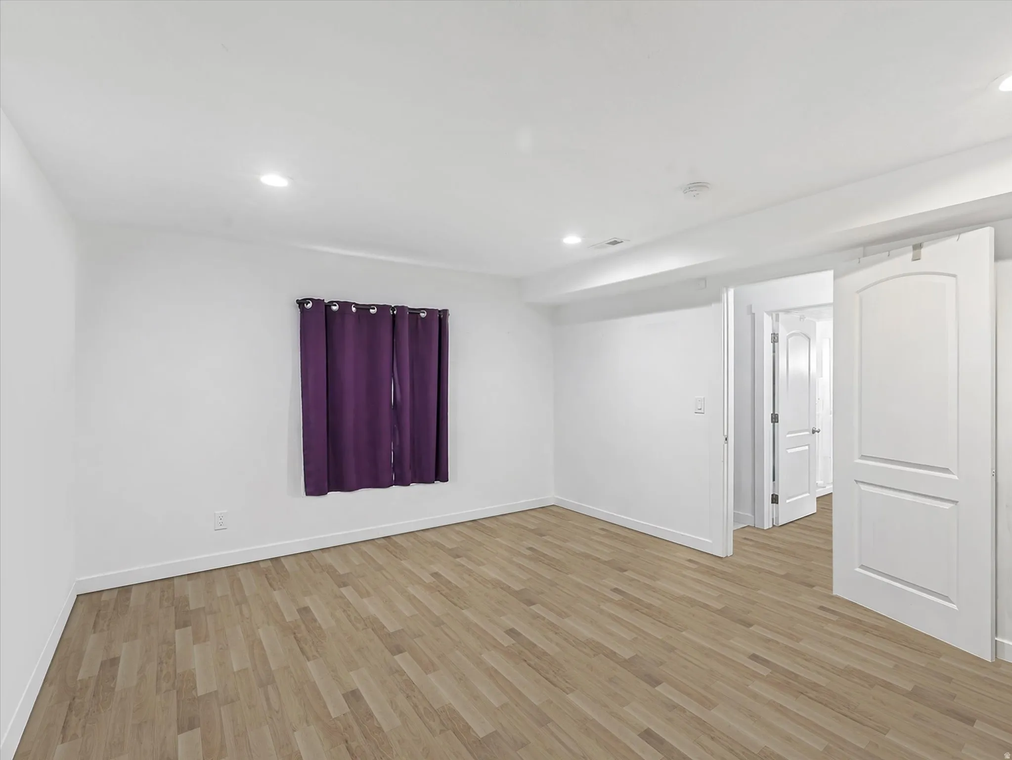 Empty room featuring light wood-style floors and recessed lighting