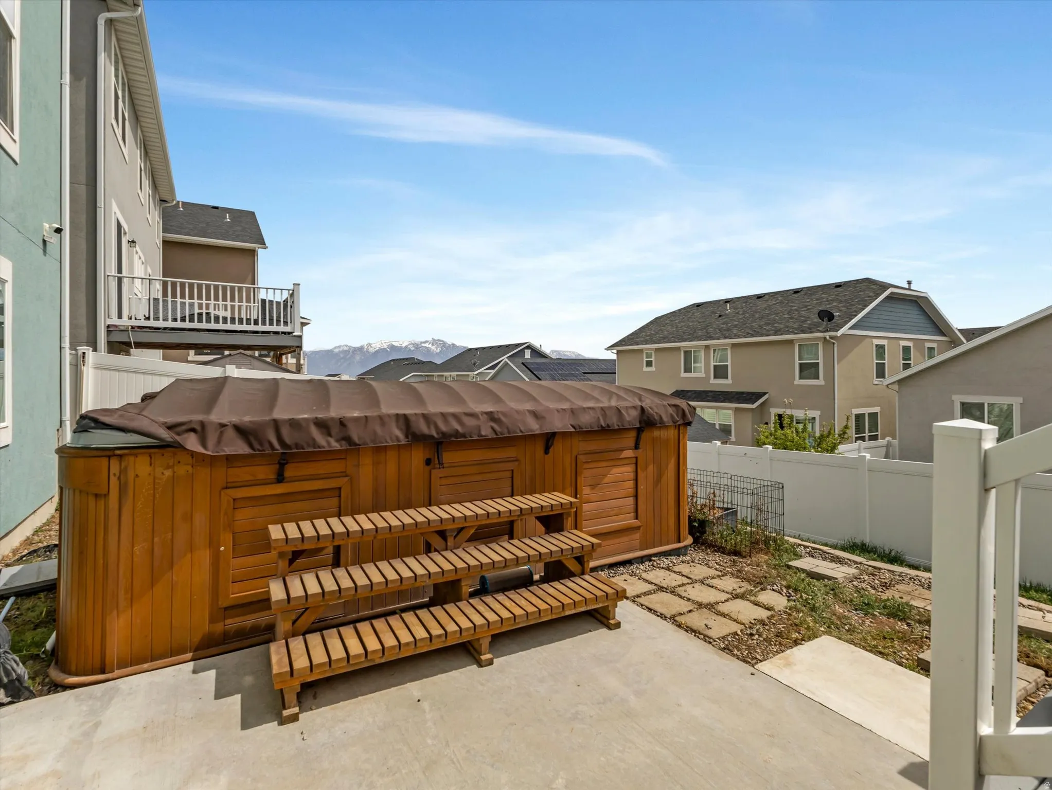 Patio / terrace with a hot tub, a fenced backyard, a patio area, and a mountain view