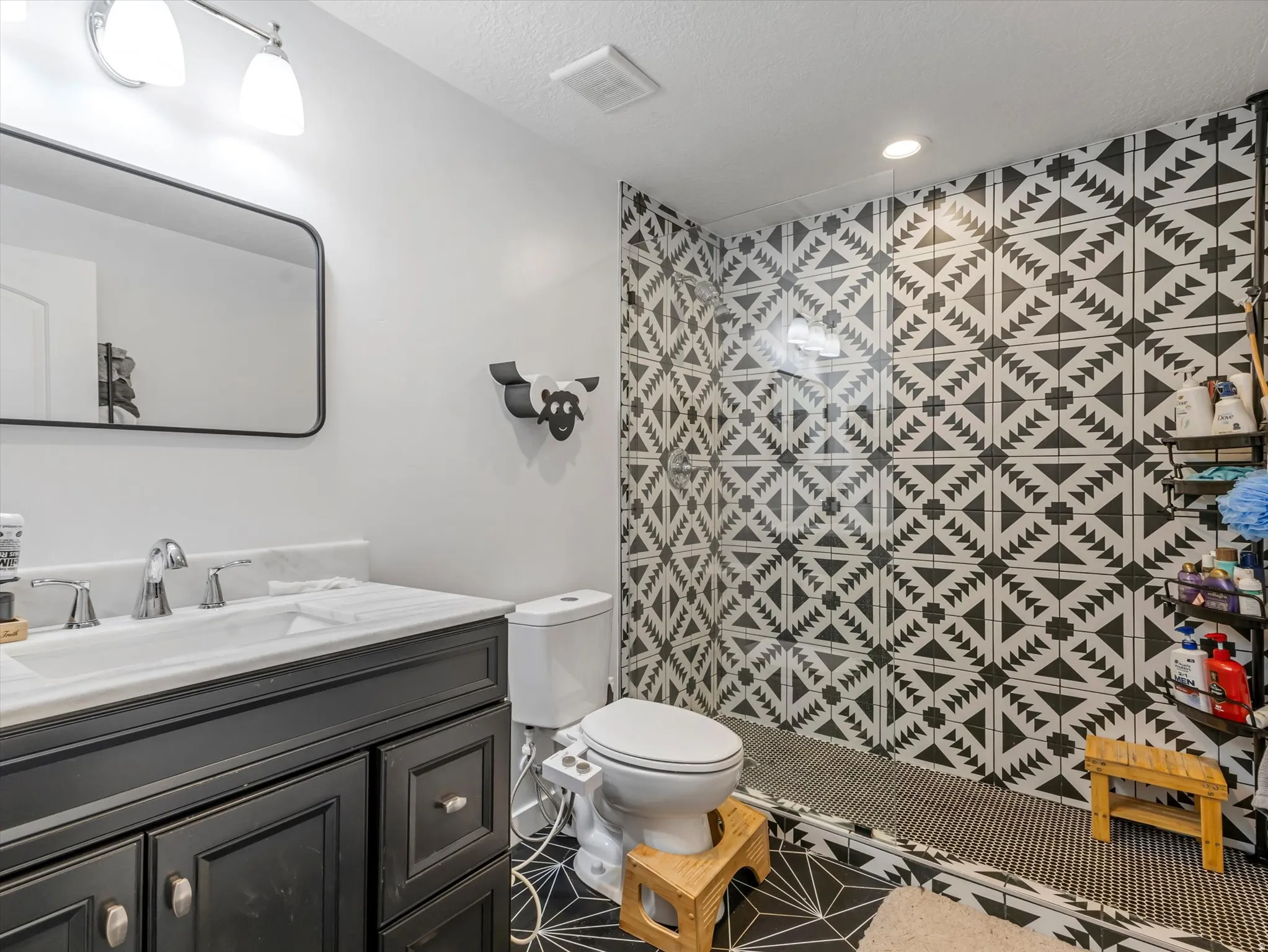 Full bath featuring vanity, a stall shower, and a textured ceiling