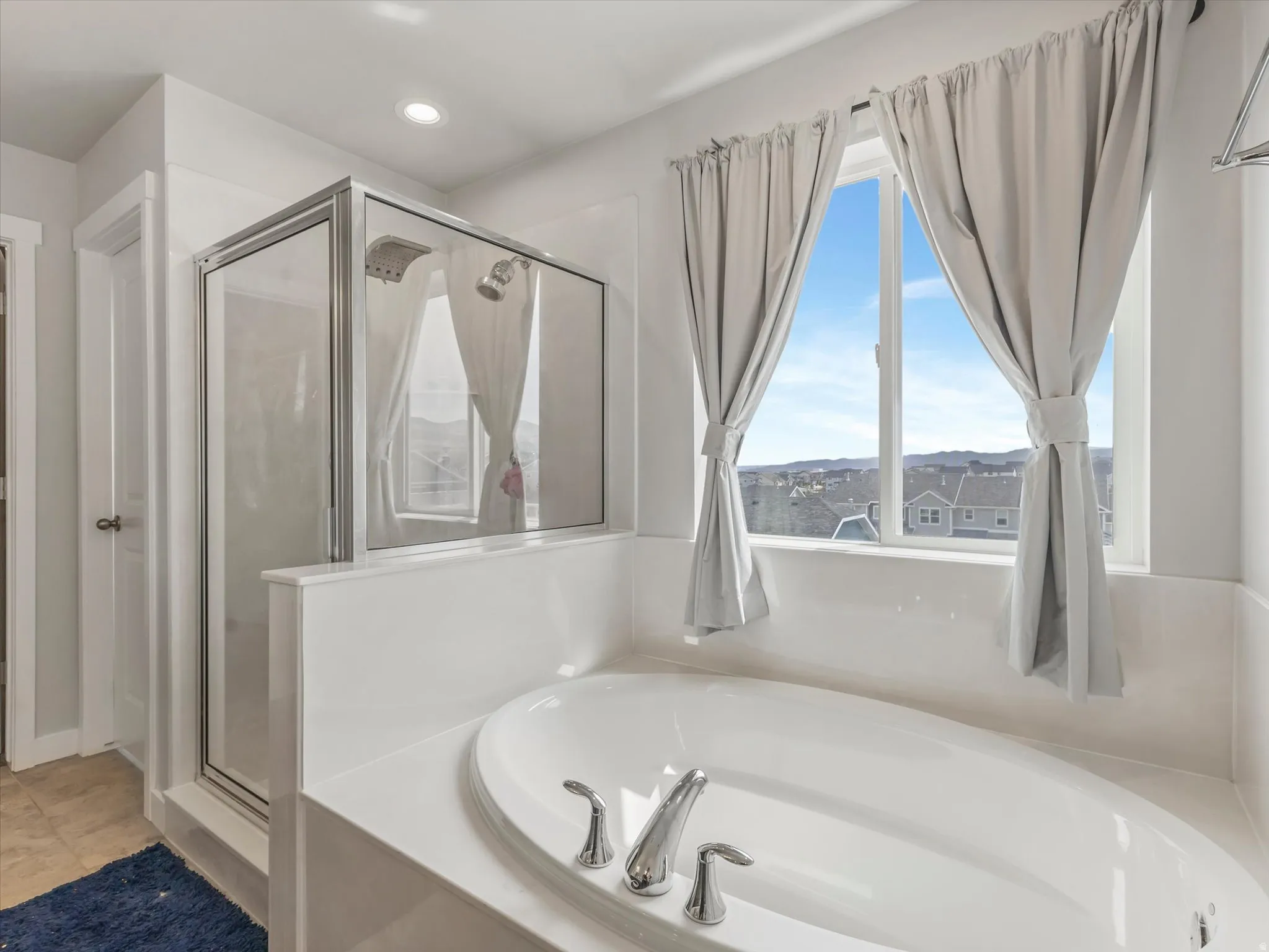 Full bath featuring a stall shower, a bath, and recessed lighting