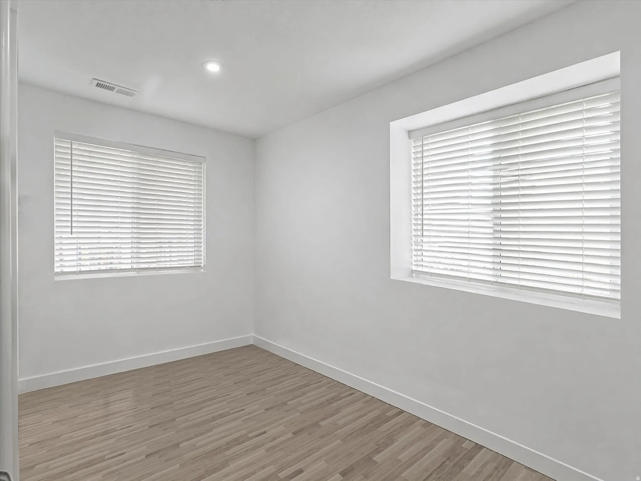 Spare room with wood finished floors and recessed lighting