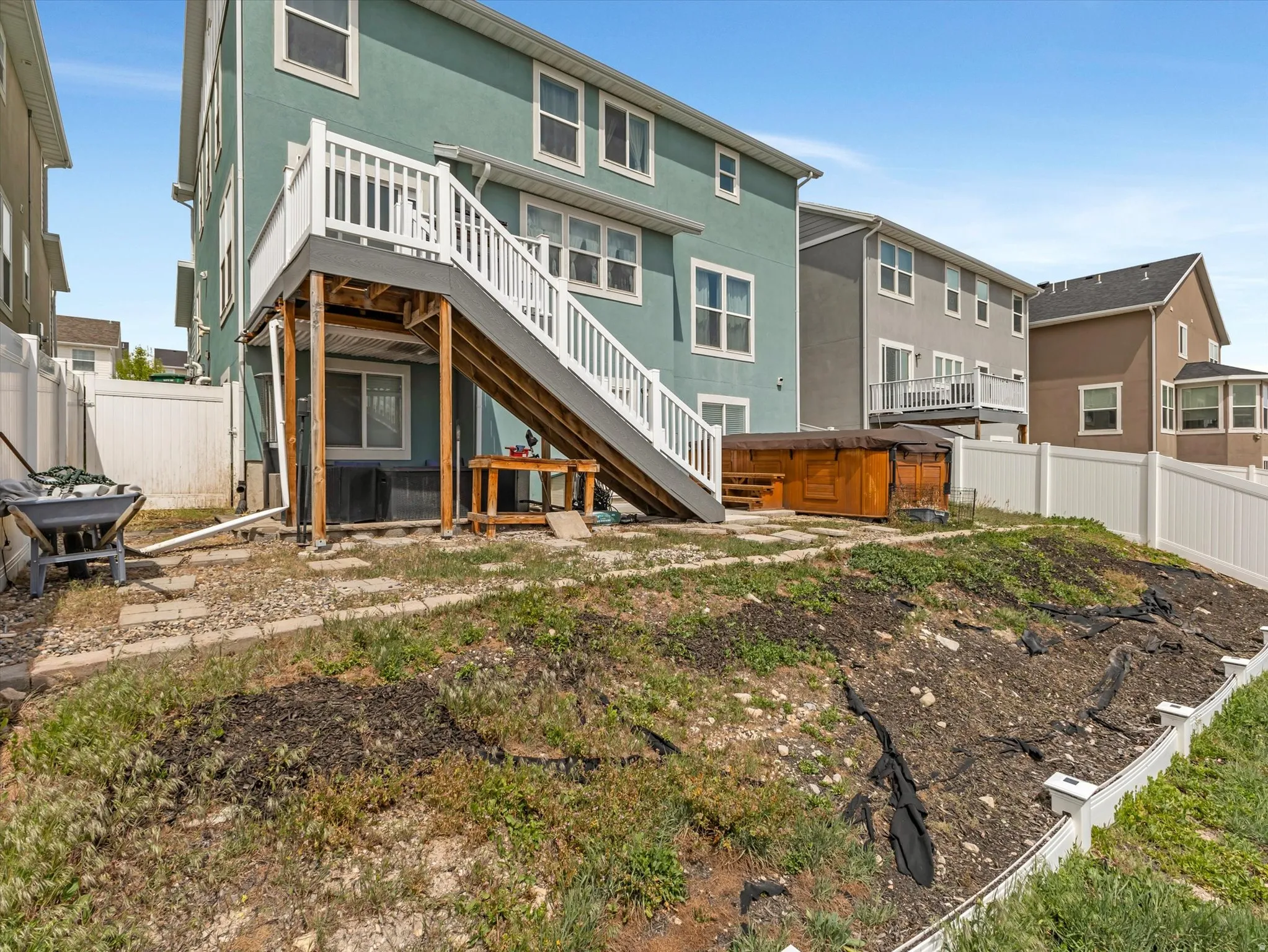 Back of house featuring a fenced backyard, a patio area, stucco siding, and a wooden deck