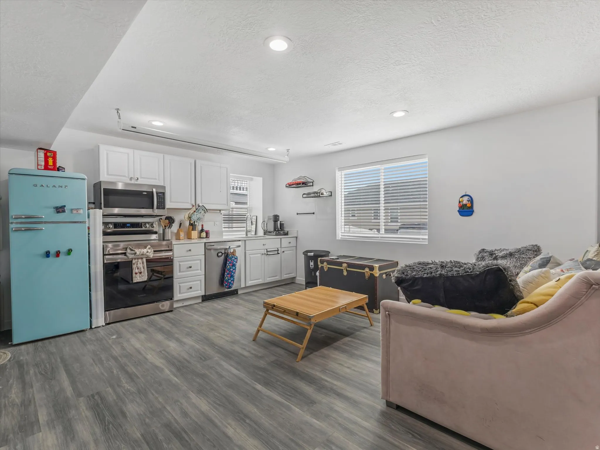 Living area with recessed lighting, dark wood finished floors, and a textured ceiling