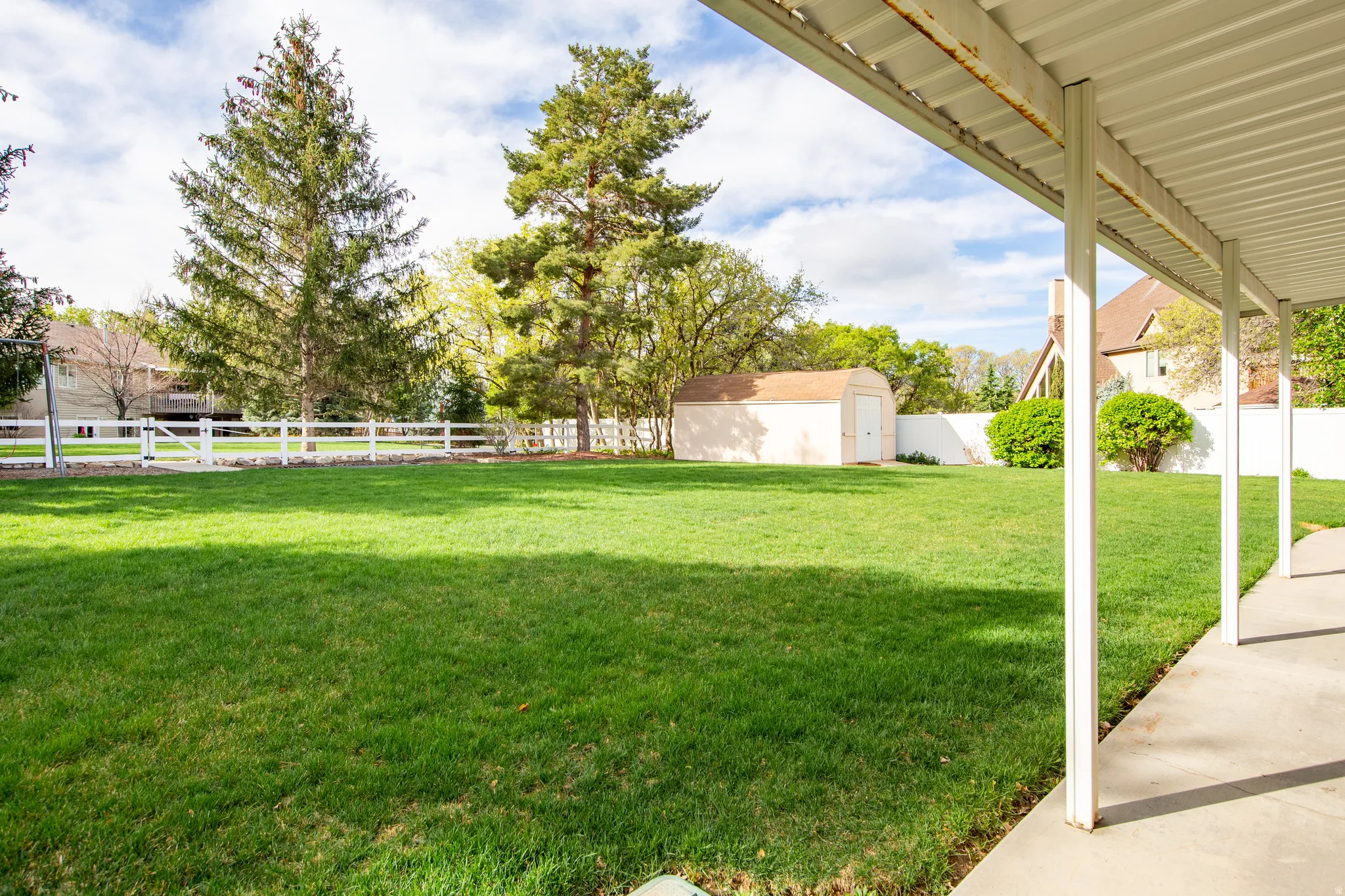 Fenced backyard with a patio area and a storage shed
