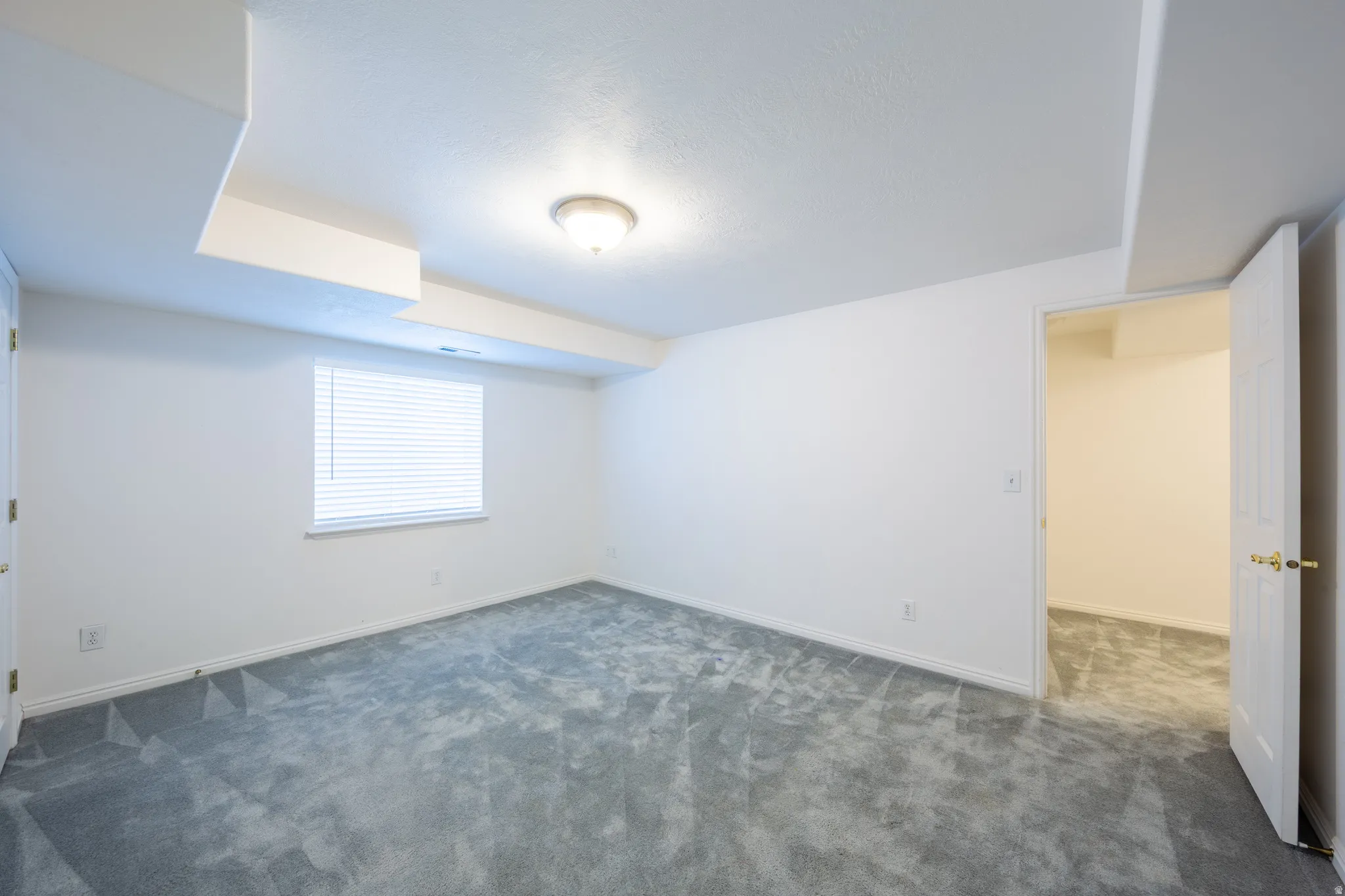Below grade area featuring dark colored carpet and baseboards