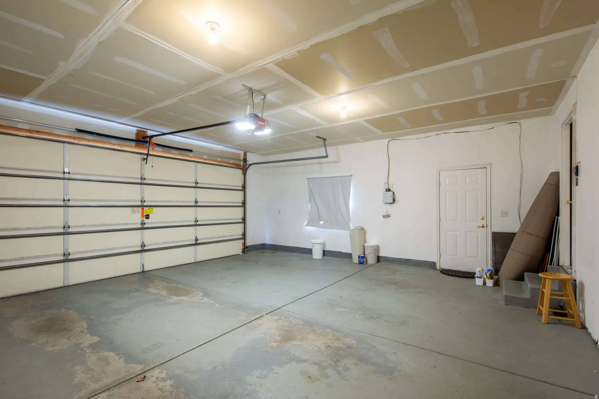 Garage with a garage door opener and baseboards