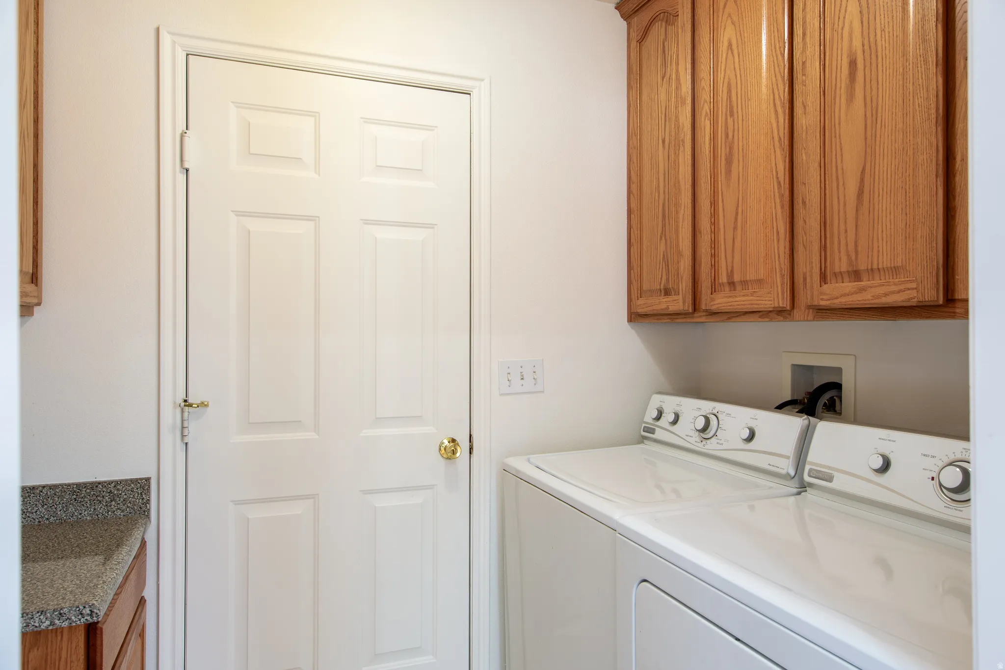 Laundry area with cabinet space and washer and clothes dryer