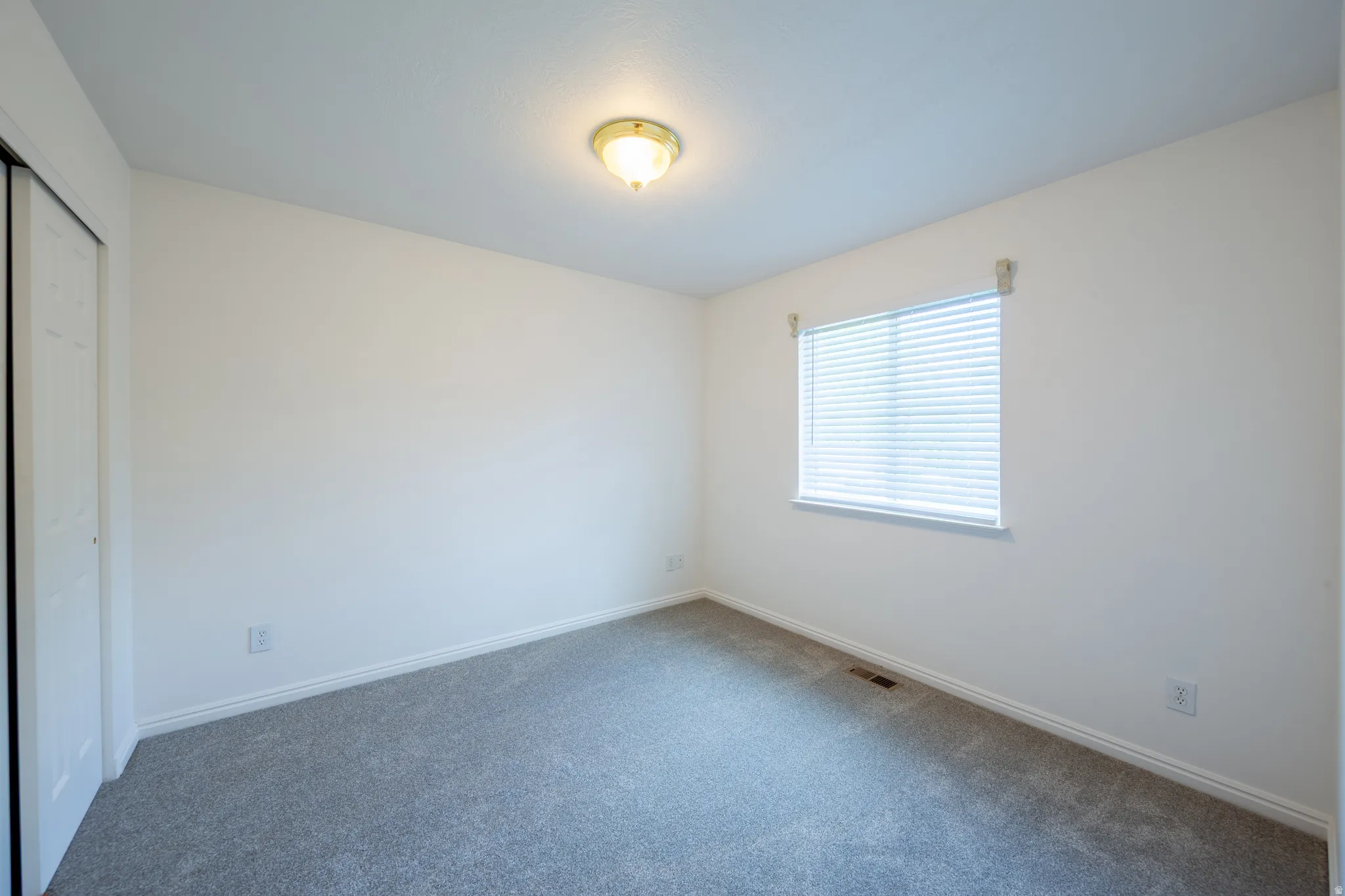 Unfurnished bedroom featuring a closet and carpet floors