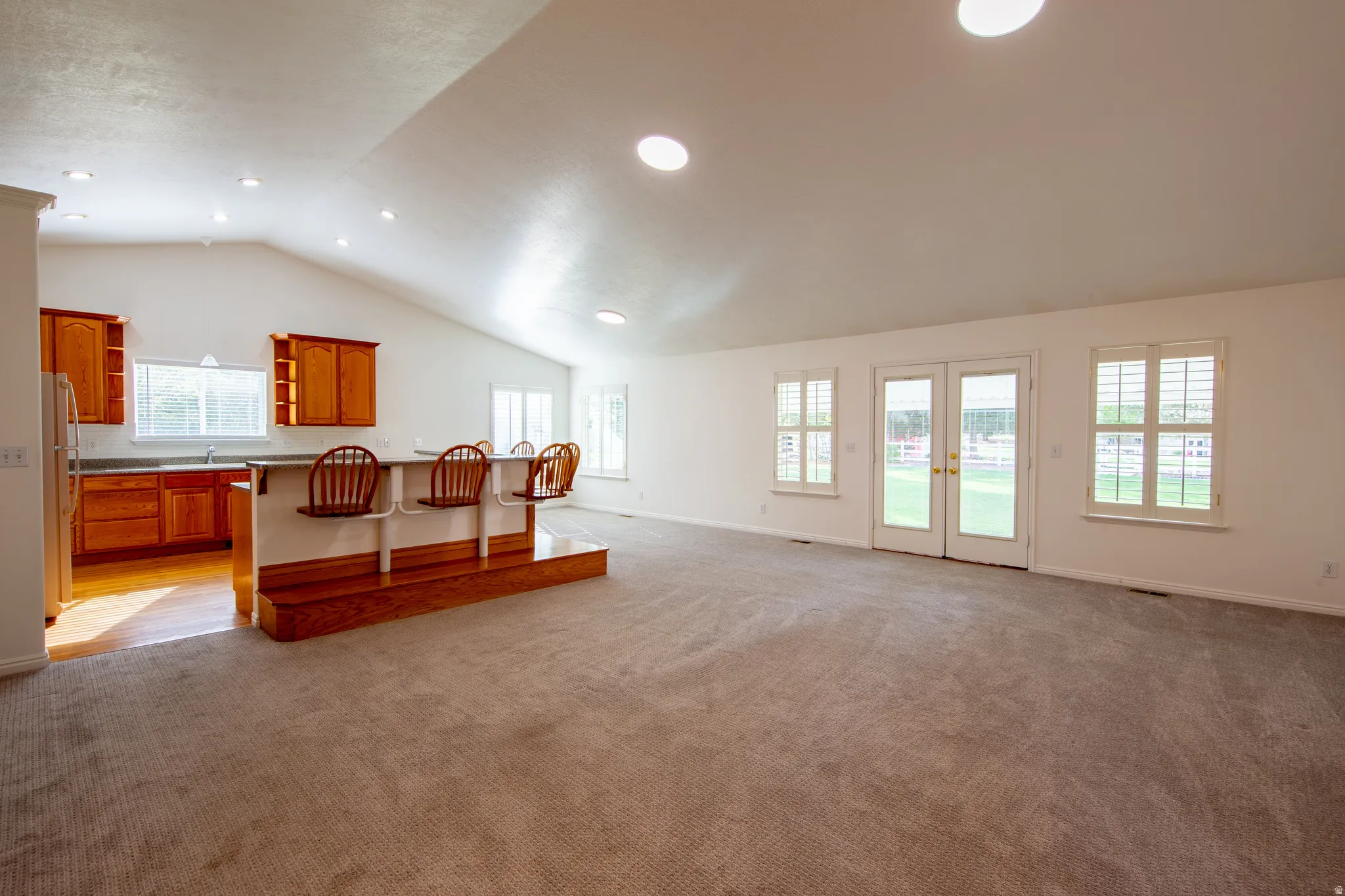 Living area featuring french doors, light colored carpet, and recessed lighting