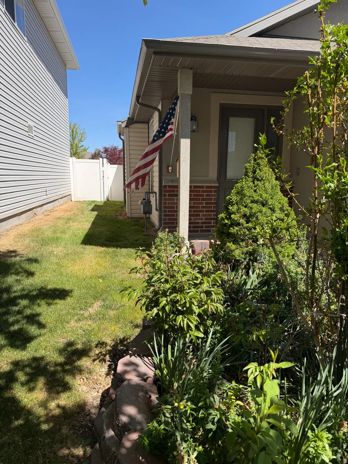 View of side of property featuring brick siding and a gate
